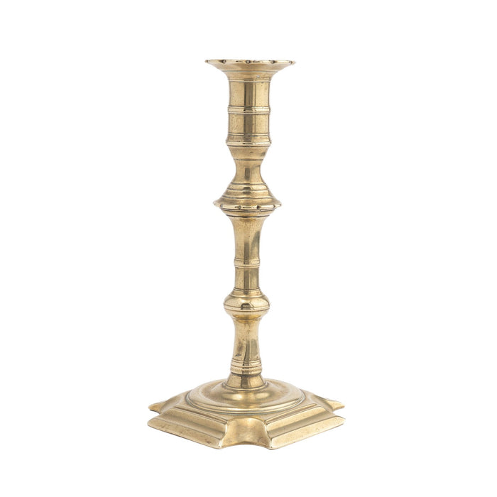 English Queen Anne cast brass cove cut corner base candlestick (c. 1725-50)