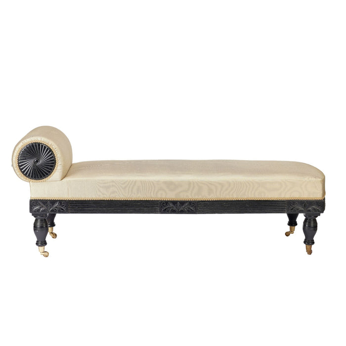 American Eastlake upholstered chaise in ebonized walnut with brass casters (1888)